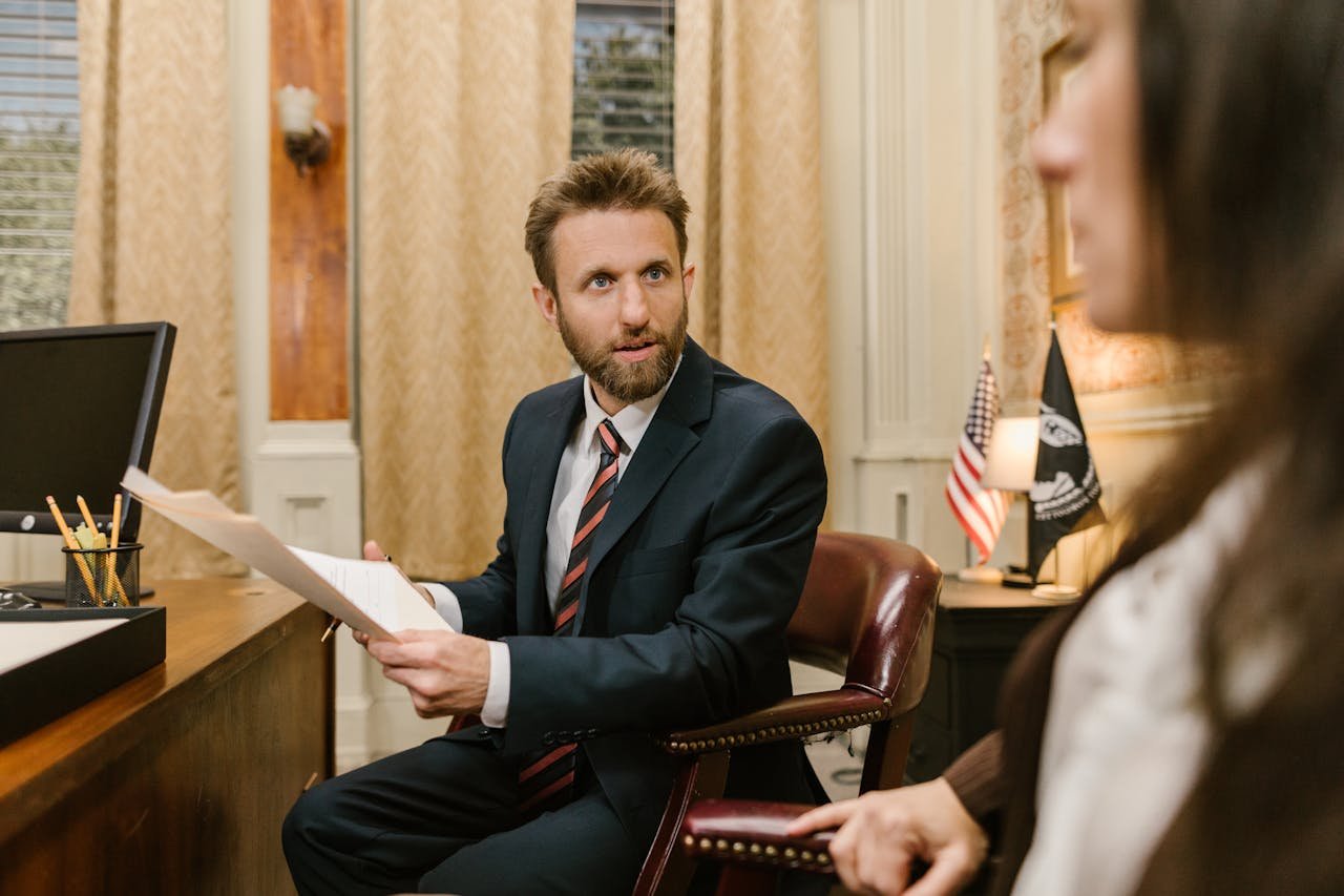 Confident black male professional in office setting consulting a tablet.