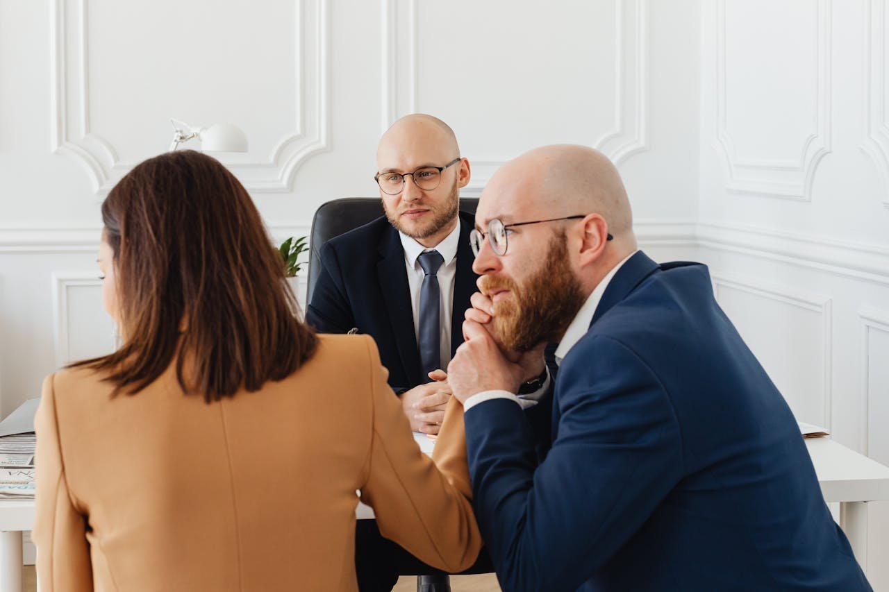 Two professionals shaking hands in an office setting, symbolizing a successful business partnership.